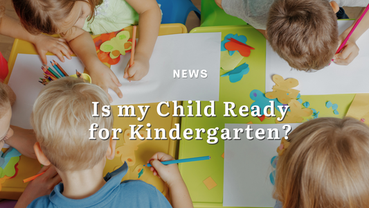5 year old kindergarten children gather round a table, drawing with brightly colored pencil crayons