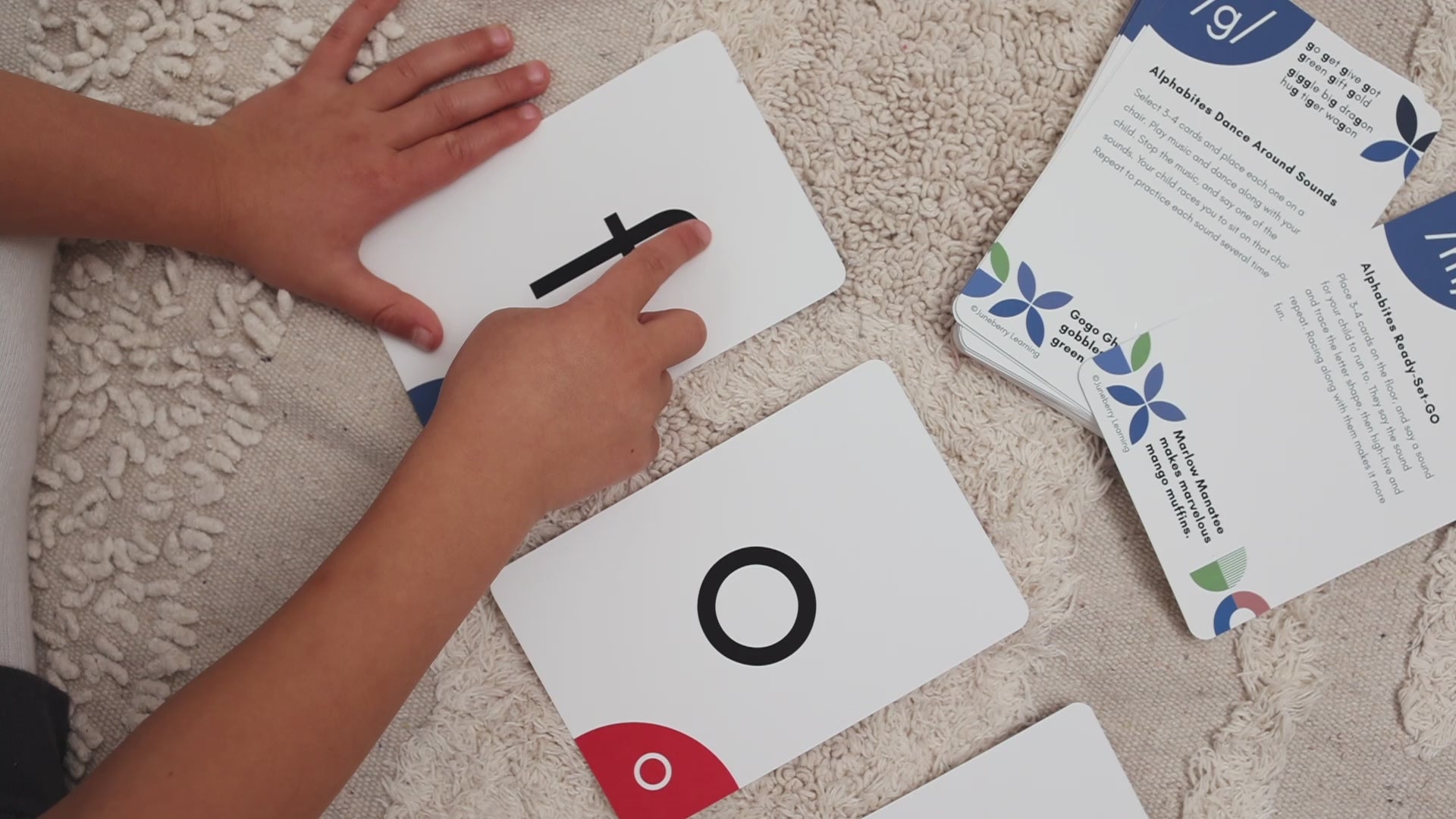 Load video: Alphabites game pack helps children learn to read in just 5 minutes a day. Children are shown tracing the letters, playing games such as throwing a ball and driving cars while saying letter sounds.